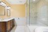 Bathroom with light tile patterned floors, tile walls, a garden tub, a shower stall, and double vanity
