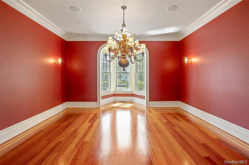 Unfurnished dining area with light wood finished floors, a chandelier, and ornamental molding