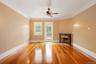 Unfurnished living room with light wood-type flooring, ornamental molding, a fireplace, and ceiling fan
