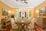 Dining area with ornamental molding, wood finished floors, a chandelier, ornate columns, and arched walkways