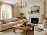 Living area with a decorative wall, a chandelier, ornamental molding, and a fireplace