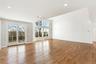Unfurnished living room with wood finished floors, lofted ceiling, and recessed lighting