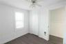 Unfurnished bedroom featuring dark wood-style floors, a ceiling fan, and a closet