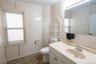 Bathroom with tile walls, vanity, ornamental molding, and dark tile patterned floors