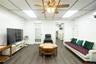 Living room featuring a drop ceiling, ceiling fan, and dark wood-style flooring