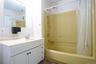 Bathroom with ornamental molding, shower / tub combo with curtain, and vanity