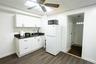 Kitchen featuring dark countertops, freestanding refrigerator, white cabinets, a paneled ceiling, and black microwave