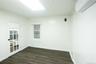 Spare room featuring dark wood-style flooring, a wall mounted air conditioner, and ornamental molding