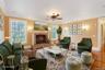 Living area with wood finished floors, crown molding, a ceiling fan, and a fireplace