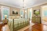 Bedroom with crown molding, wood-type flooring, and a chandelier