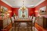 Dining space with wood finished floors, crown molding, and a chandelier