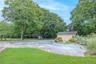 Outdoor pool with an outdoor structure, view of wooded area, and a patio