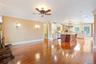 Living area with a brick fireplace, light wood-type flooring, ornamental molding, a ceiling fan, and recessed lighting
