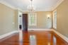 Empty room featuring ornamental molding, wood finished floors, and a chandelier