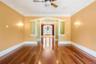 Spare room with hardwood / wood-style floors, crown molding, arched walkways, a chandelier, and decorative columns