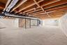 Unfinished basement with heating unit and gas water heater