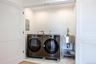 Laundry room with electric panel and washer and dryer