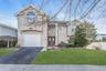 View of front of property with stucco siding, asphalt driveway, and a garage