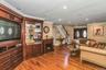 Living room featuring ornamental molding, dark wood finished floors, stairs, a glass covered fireplace, and recessed lighting
