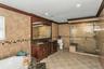 Full bathroom with crown molding, double vanity, tile walls, a stall shower, and a bath