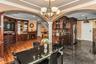 Dining area with arched walkways, ornamental molding, stairs, and a chandelier