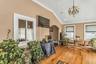 Living room featuring arched walkways, wood finished floors, lofted ceiling, a chandelier, and crown molding