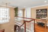 Corridor with an upstairs landing, a chandelier, wood finished floors, ornamental molding, and recessed lighting