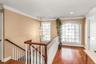 Corridor featuring an upstairs landing, a chandelier, ornamental molding, and wood finished floors
