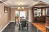 Dining space featuring a chandelier, granite tiled floors, arched walkways, and crown molding