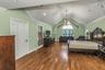Bedroom with crown molding, vaulted ceiling, a chandelier, and dark wood-style floors