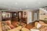 Living area featuring a glass covered fireplace, wood finished floors, crown molding, stairs, and recessed lighting