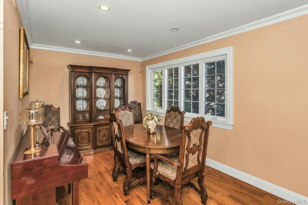 Dining space with light wood finished floors, ornamental molding, and recessed lighting