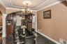 Dining room with arched walkways, granite tiled floors, ornamental molding, and a chandelier