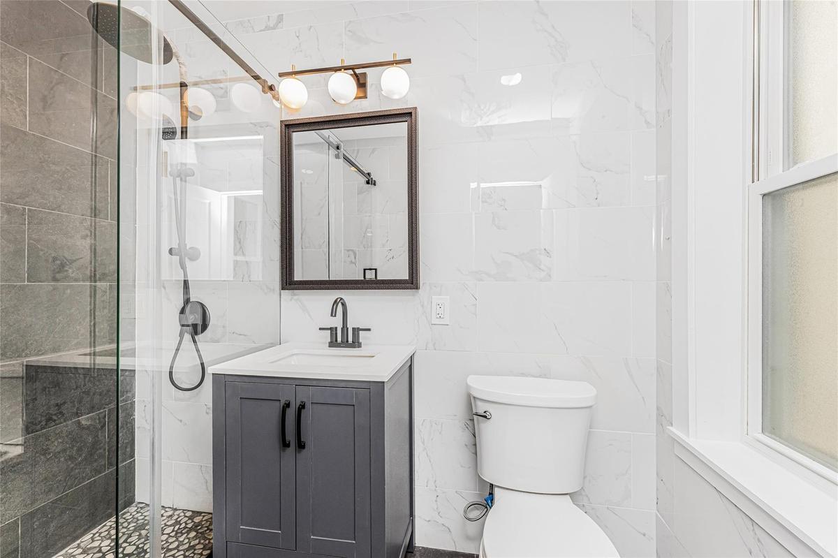 Bathroom featuring tile walls, vanity, and a stall shower