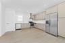 Kitchen featuring appliances with stainless steel finishes, wall chimney range hood, light wood-style flooring, light countertops, and recessed lighti