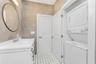 Bathroom featuring stacked washing machine and dryer, tile walls, vanity, and tile patterned floors