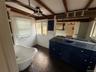 Bathroom with tile walls, a freestanding bath, vanity, and beamed ceiling