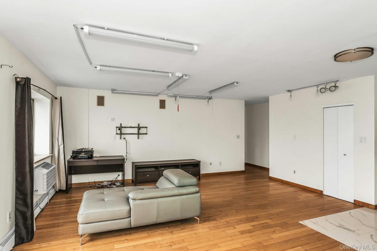 Sitting room featuring hardwood / wood-style flooring, baseboard heating, and a baseboard radiator