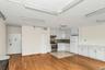 Kitchen featuring white cabinetry, freestanding refrigerator, gas range, light countertops, and light wood-style floors