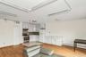 Kitchen with white cabinetry, freestanding refrigerator, stainless steel gas range oven, light wood-type flooring, and baseboard heating