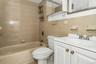 Full bathroom with vanity,  shower combination, and tile walls
