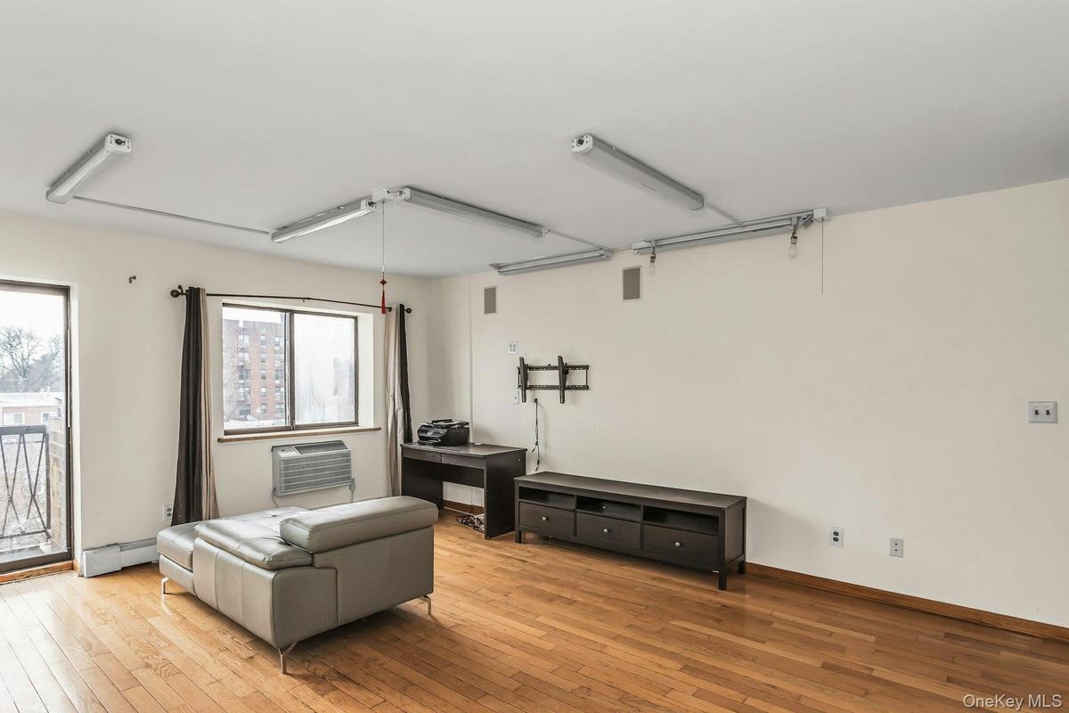 Sitting room featuring wood-type flooring and baseboard heating