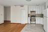 Kitchen featuring white cabinets, stainless steel range with gas stovetop, freestanding refrigerator, and decorative backsplash