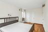 Bedroom featuring light wood-style flooring and a baseboard heating unit