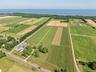 Overview of rural landscape featuring abundant farmland and a nearby body of water