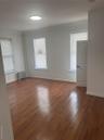 Empty room with radiator heating unit, dark wood-style floors, and baseboards