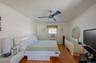 Bedroom with cooling unit, wood finished floors, ceiling fan, and radiator heating unit