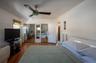 Bedroom with multiple closets, wood finished floors, radiator heating unit, and a ceiling fan
