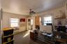 Home office featuring radiator, a ceiling fan, and carpet flooring