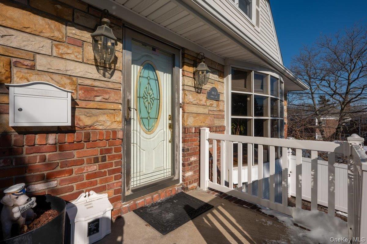 View of exterior entry featuring brick siding and stone siding